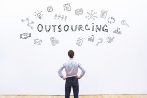 businessman looking at word outsourcing