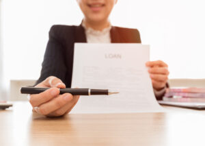 A woman holding a loan document ready to be signed